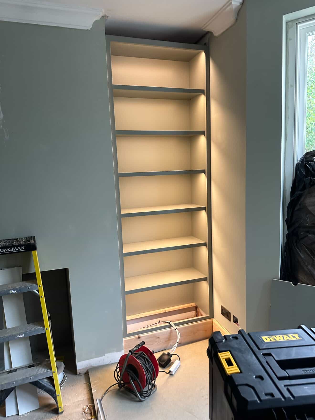 Built-in bookshelf with LED strip lighting installation in progress in Crawley